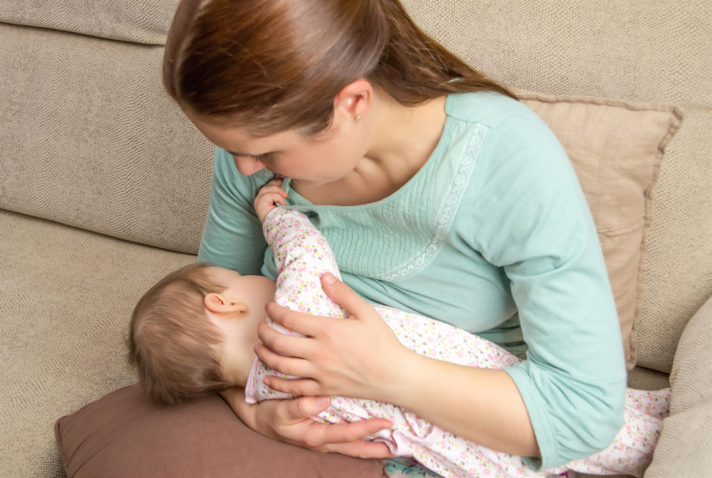 Young mother breast feeding her baby 
